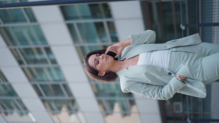 Confident Businesswoman Chats on Phone in Vienna Cityscape