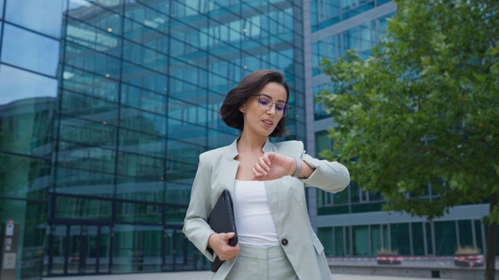 Businesswoman Checks Time Amid Vienna's Urban Landscape