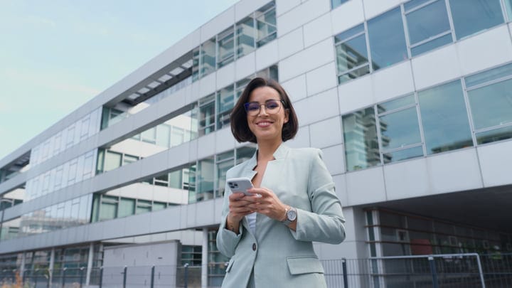 Confident Businesswoman Engages with Her Smartphone Outdoors