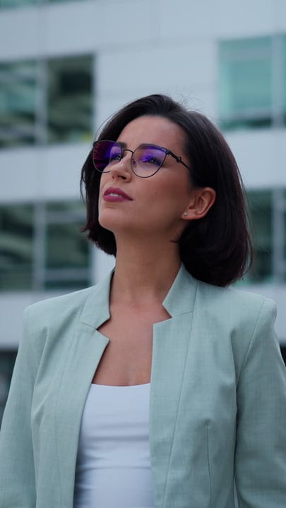 Confident Businesswoman Gazes Upwards In Vienna's Urban Landscape