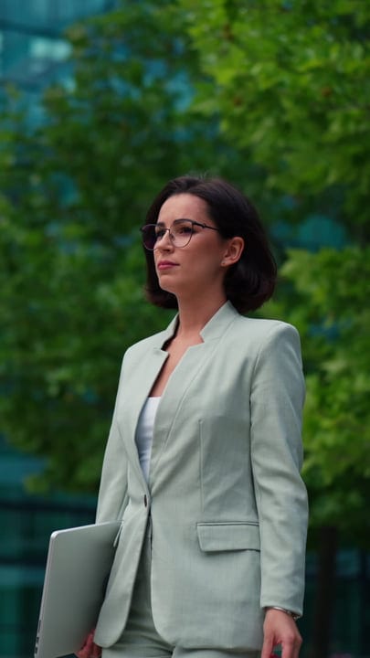 Confident Businesswoman Walks Through Vienna's Urban Green Spaces