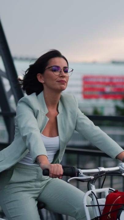 Confident Businesswoman Cycling Through Vienna's Evening Streets