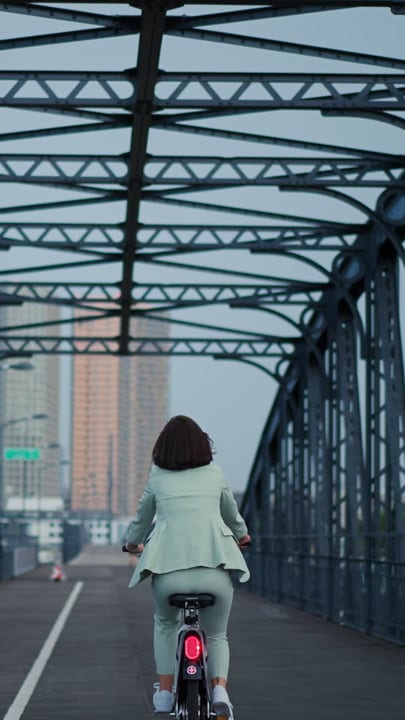 Businesswoman Rides Through Vienna's Urban Landscape on Bicycle