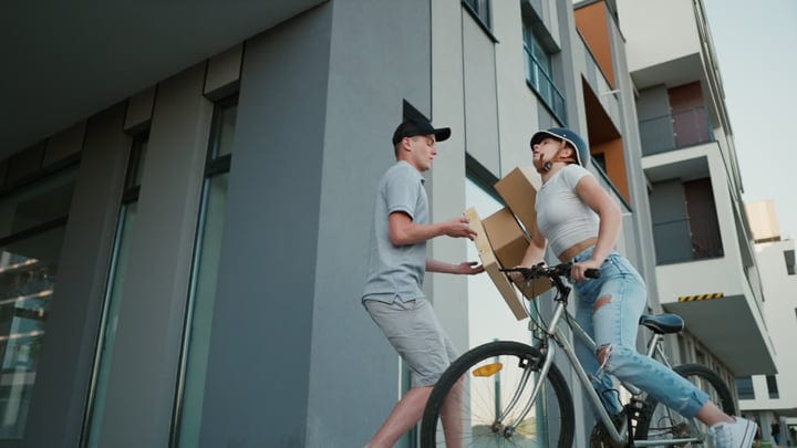 Bicycle Courier Delivers a Package In Modern Cityscape