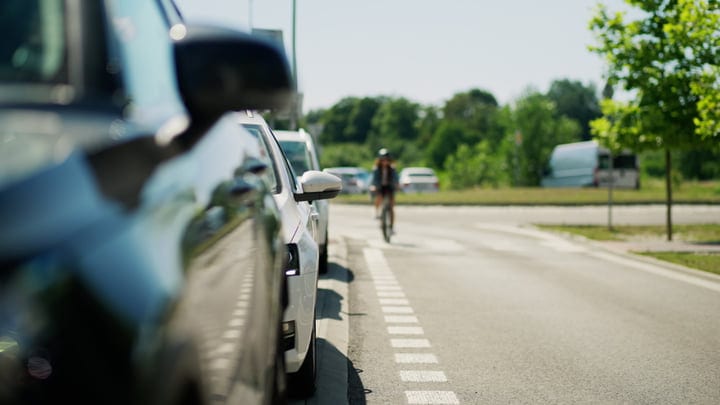 Cyclist Glides Through Suburban Street on Sunny Day