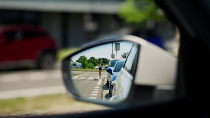 A Courier's Journey Reflected In The Rearview Mirror
