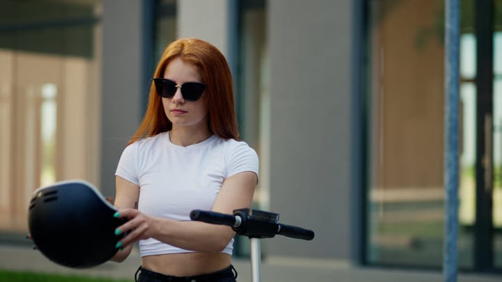 Young Woman Prepares For Scooter Ride In The City
