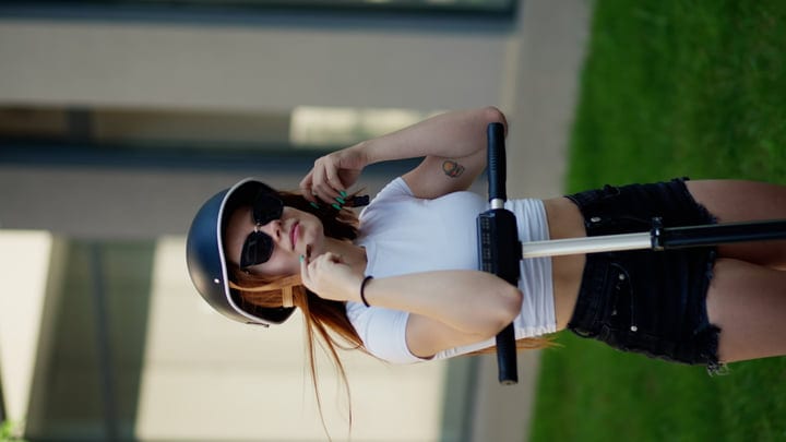 Young Woman Adjusts Helmet Before Urban Scooter Ride