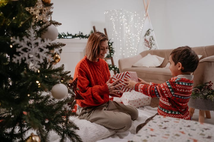Joyful Exchange Of Gifts By The Christmas Tree