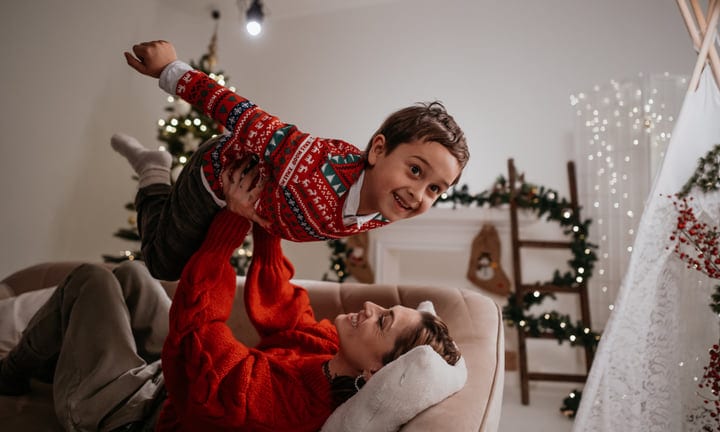 Joyful Holiday Moments: Child Flying in Festive Living Room