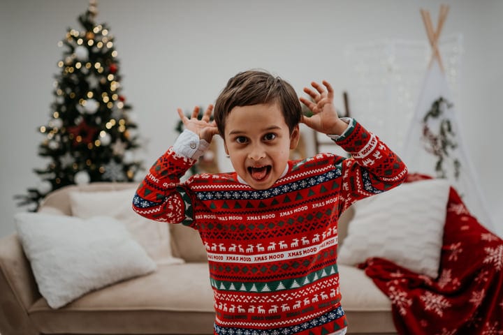 Joyful Child in Festive Pajamas Celebrates Christmas Spirit