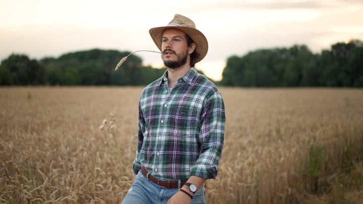 Contemplative Farmer in Golden Wheat Field at Dusk