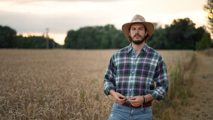 A Farmer Gazes Thoughtfully Across Golden Fields