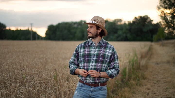 Contemplative Farmer Stands Amidst Golden Wheat Fields