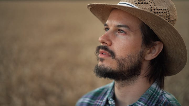 Pensive Farmer Looks to the Horizon in Summer Light
