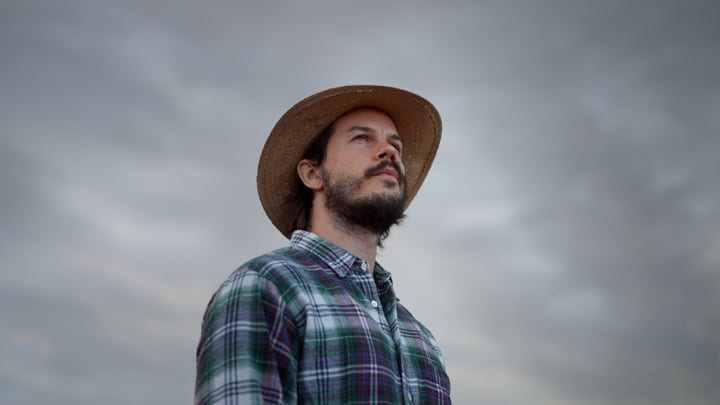 Contemplative Farmer Gazing at Overcast Sky in Autumn