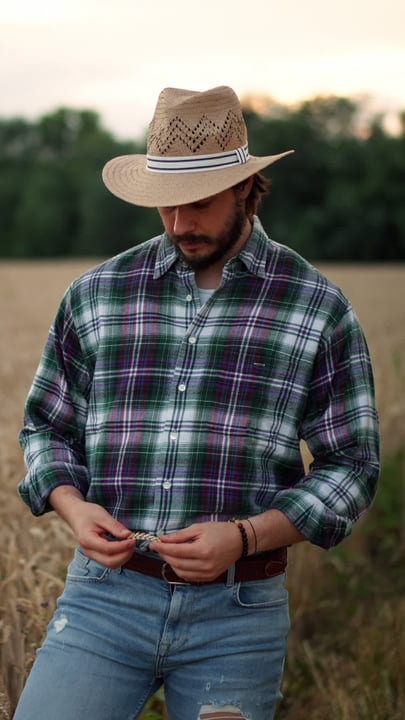 A Farmer Inspects His Crops at Dusk in the Field