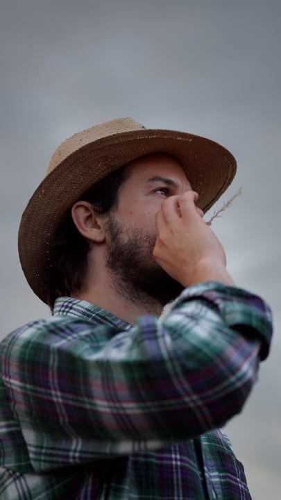 Thoughtful Farmer Gazing Into The Distance Under Gray Skies
