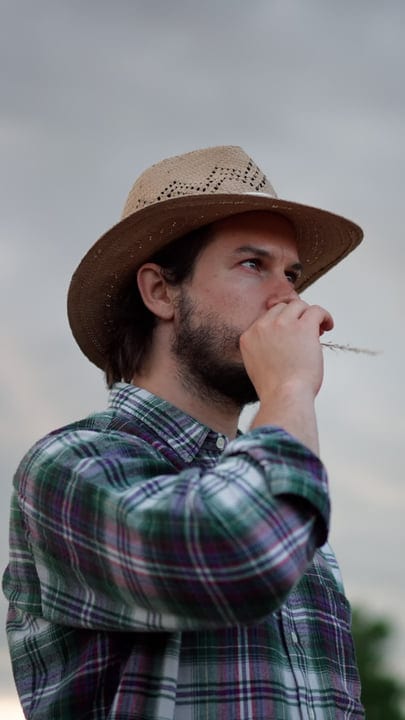 Contemplative Farmer Gazes Over Fields in Evening Light