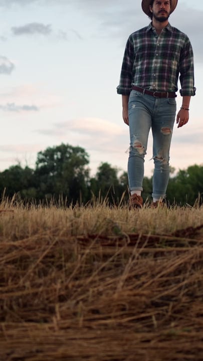 Modern Farmer Strolls Through Autumn Fields at Dusk