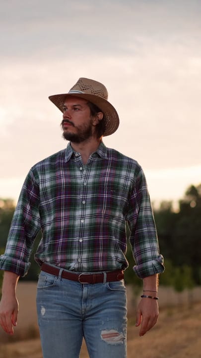 A Farmer Embraces Sunset In A Rustic Landscape