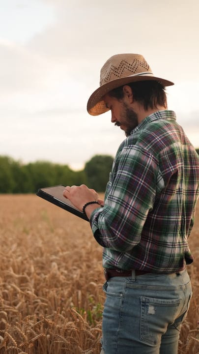Modern Farmer Embraces Technology in Golden Wheat Field