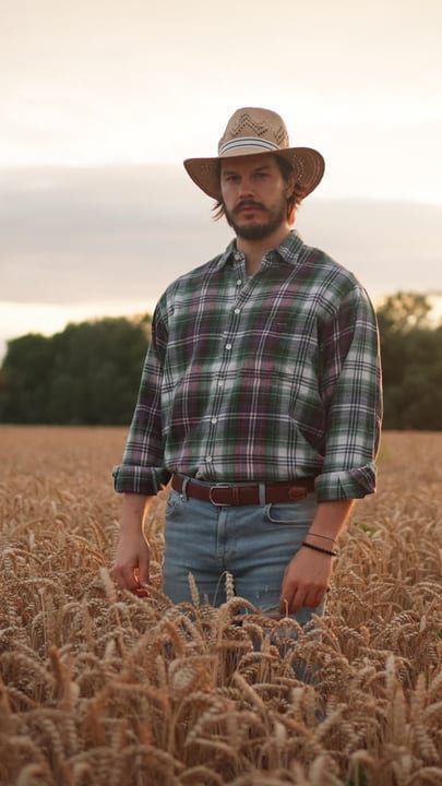 Contemplative Farmer Standing Amidst Golden Wheat Fields