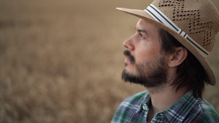 Pensive Farmer Gazes Over Golden Wheat Fields