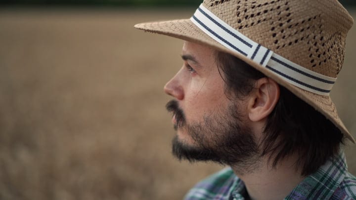 Contemplative Farmer Gazing Across Golden Wheat Fields