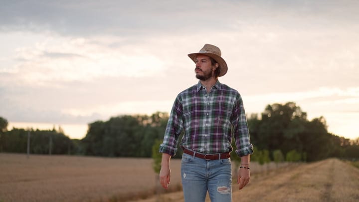 Young Farmer Embracing The Horizon At Sunset
