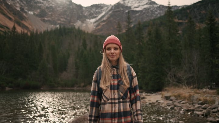 Young Woman Enjoys Solitude By Mountain Lake