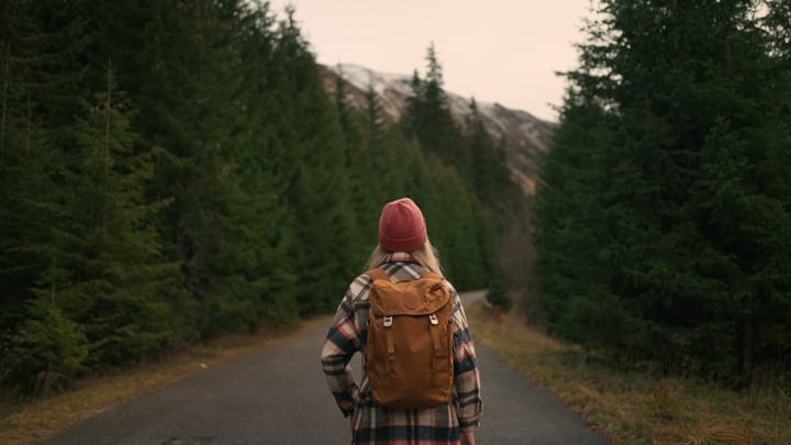 Female Hiker Embraces Solitude On A Mountain Path