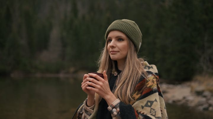 Young Woman Embraces Serene Wilderness With Warm Drink