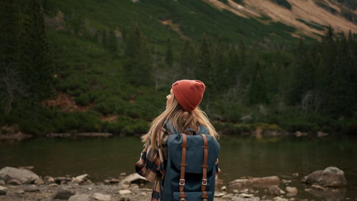 Exploring Tranquil Wilderness With A Backpack And Beanie