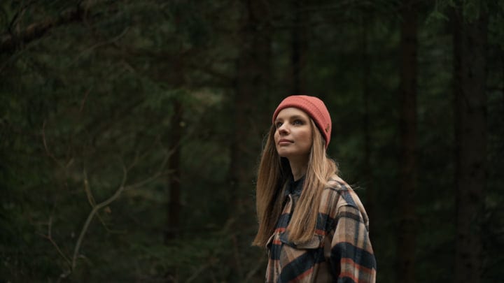 Contemplative Hiker Embraces Tranquility In Lush Forest