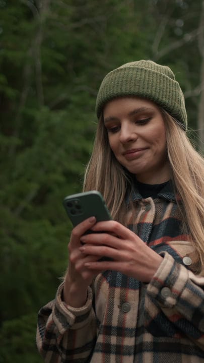 Young Adventurer Checks Her Phone In The Forest