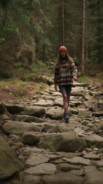 Young Woman Adventuring Through Rugged Forest Path