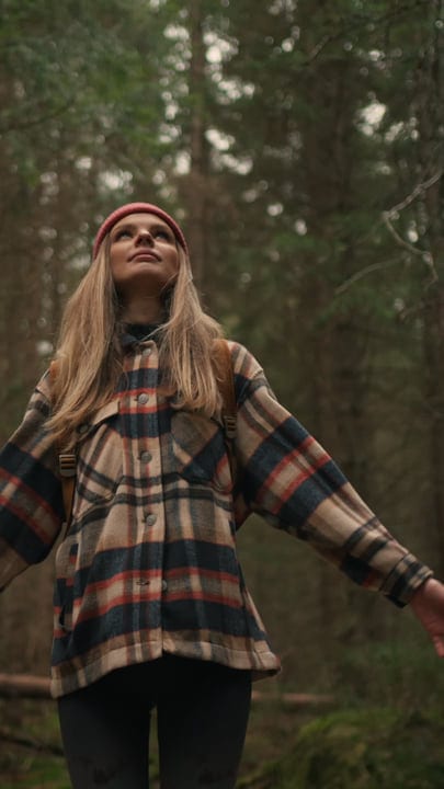 Embracing Nature In A Cozy Plaid Jacket In The Woods