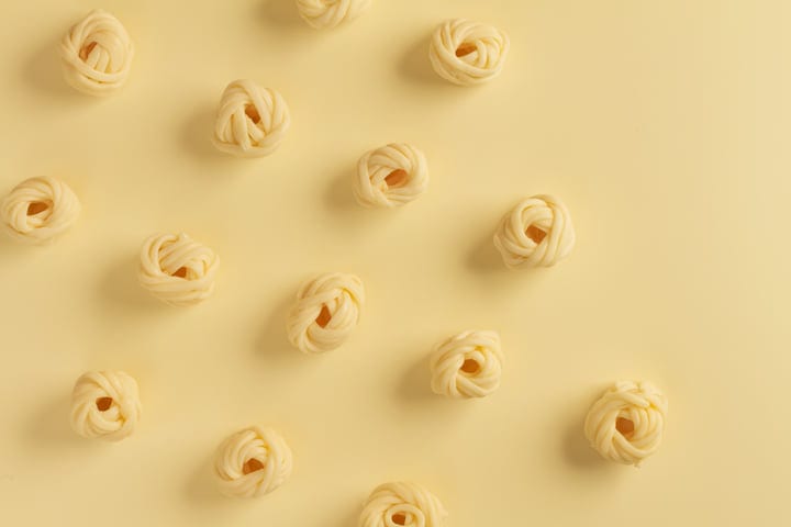 Perfectly Arranged Pasta Nests On A Soft Beige Surface