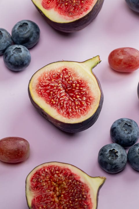Vibrant Figs And Berries Arranged On Pastel Background