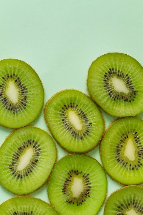 Kiwi Slices Arranged on a Fresh Mint Backdrop