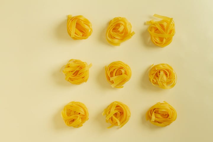 Golden Pasta Nests Arranged on a Soft Yellow Canvas