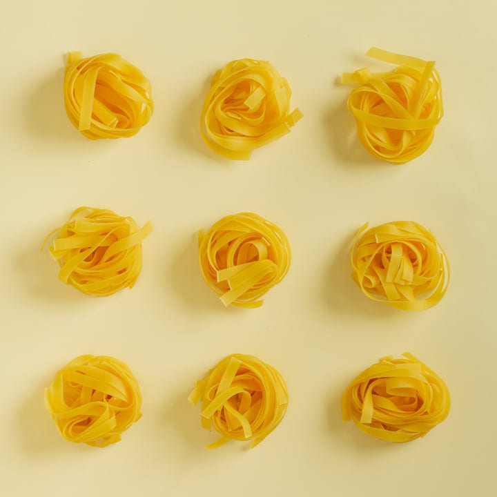 Golden Pasta Nests Arranged In A Grid Against Yellow