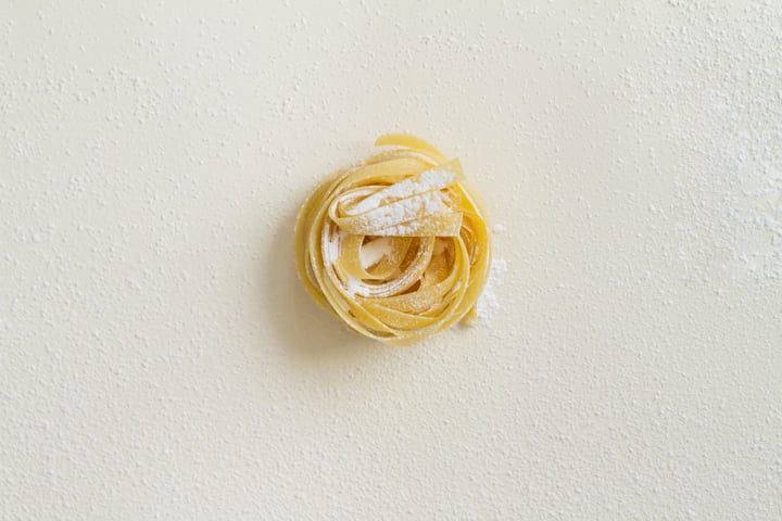 Elegantly Arranged Pasta Nest On Flour-Dusted Surface