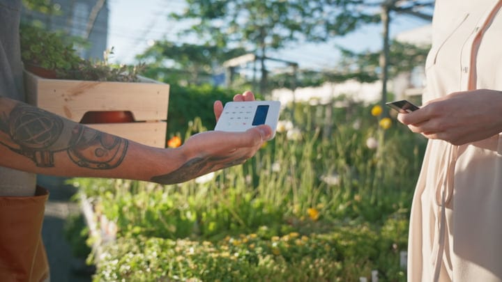 Gardener Completes A Contactless Payment In Greenhouse Setting