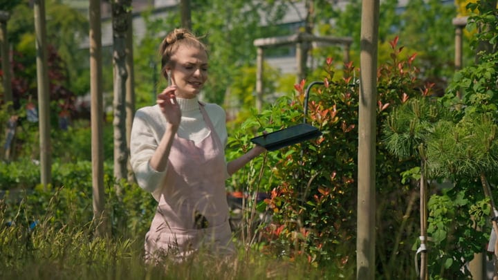 Gardener Balances Technology And Nature In Greenhouse Scene