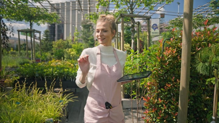 Young Gardener Embraces Nature in Lush Greenhouse