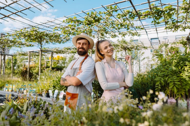Gardeners Embrace the Sunshine in a Lush Greenhouse