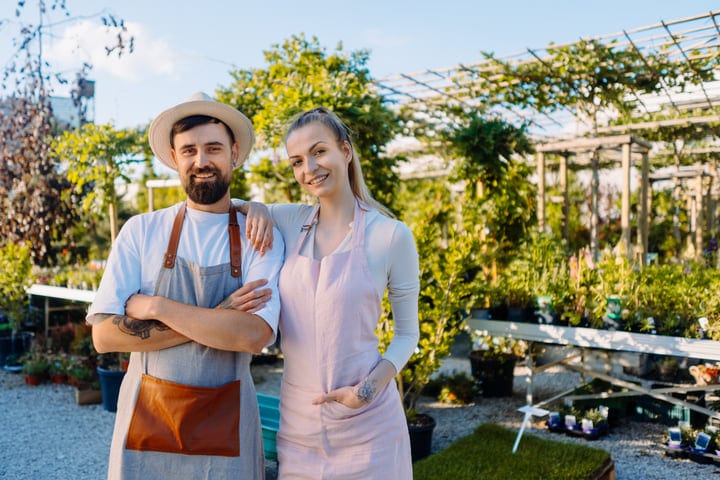 Happy Gardeners Embrace Their Craft in Vibrant Greenhouse