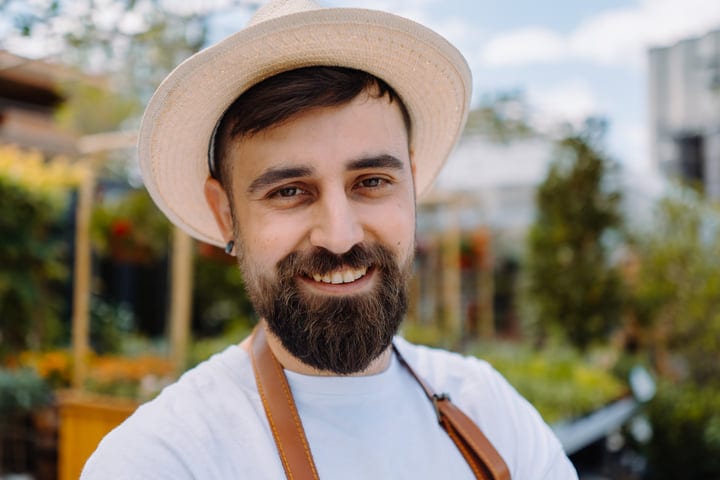 Smiling Gardener Enjoys a Sunny Day in the Greenhouse